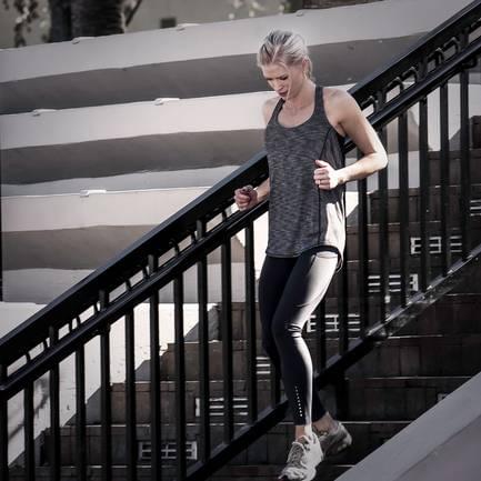 Jessica jogging down outdoor stairs in fitness attire